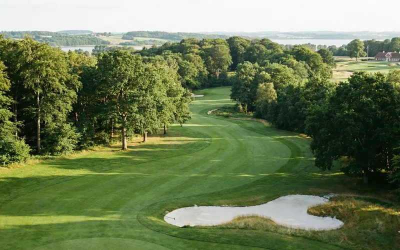 Parkland-Fairway des Falster Golfklub bei Eskilstrup mit altem Baumbestand und Blick zum Guldborgsund