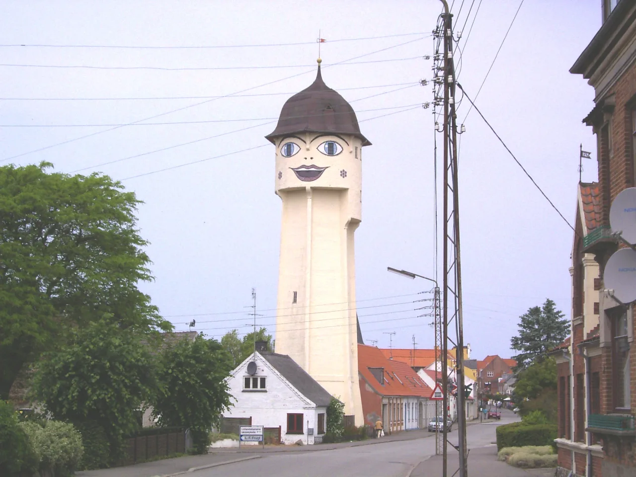 Sakskøbing-Wasserturm Saksine mit aufgemaltem Smiley-Gesicht, Stadtkulisse mit Backsteinhäusern