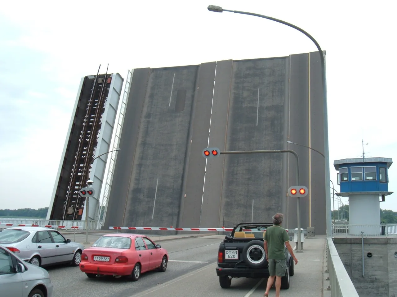 Frederik-IX-Brücke in Nykøbing F. mit aufgeklappten Bascules — Autos warten, dahinter der Brückenwärterturm